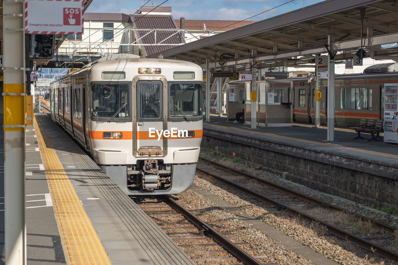 rail transportation, transportation, mode of transportation, track, railroad track, public transportation, train, vehicle, metropolitan area, architecture, travel, train station, land vehicle, railroad station platform, railroad station, transport, city, electricity, public transport, built structure, railway, day, station, outdoors, building exterior, nature, sky, no people, rolling stock, motion, arriving, city life