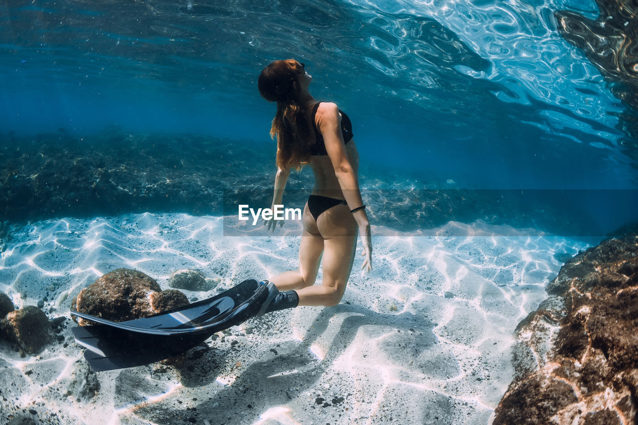 full length of woman swimming in sea