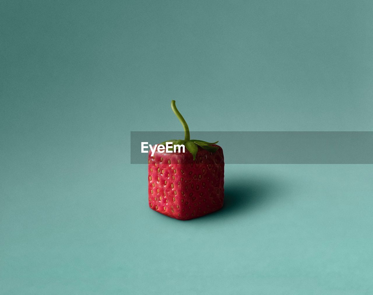 Close-up of strawberry against colored background