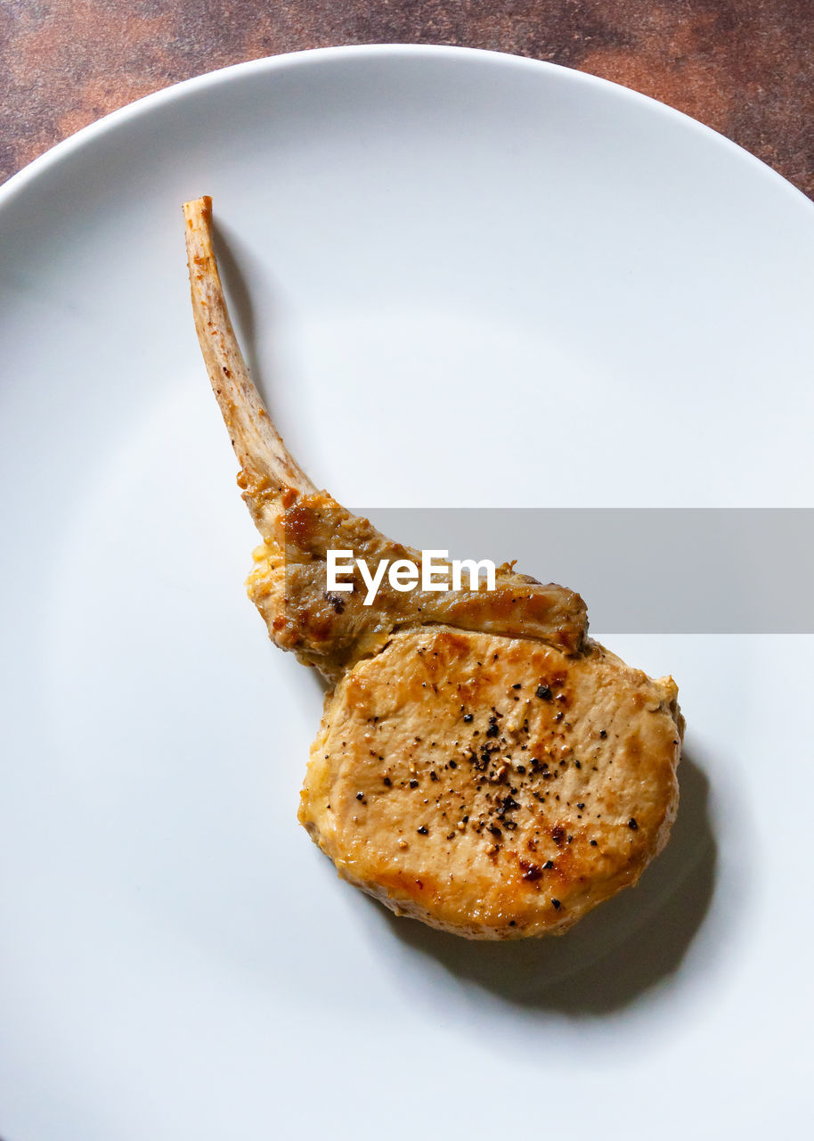 HIGH ANGLE VIEW OF BREAD IN PLATE AGAINST WHITE BACKGROUND