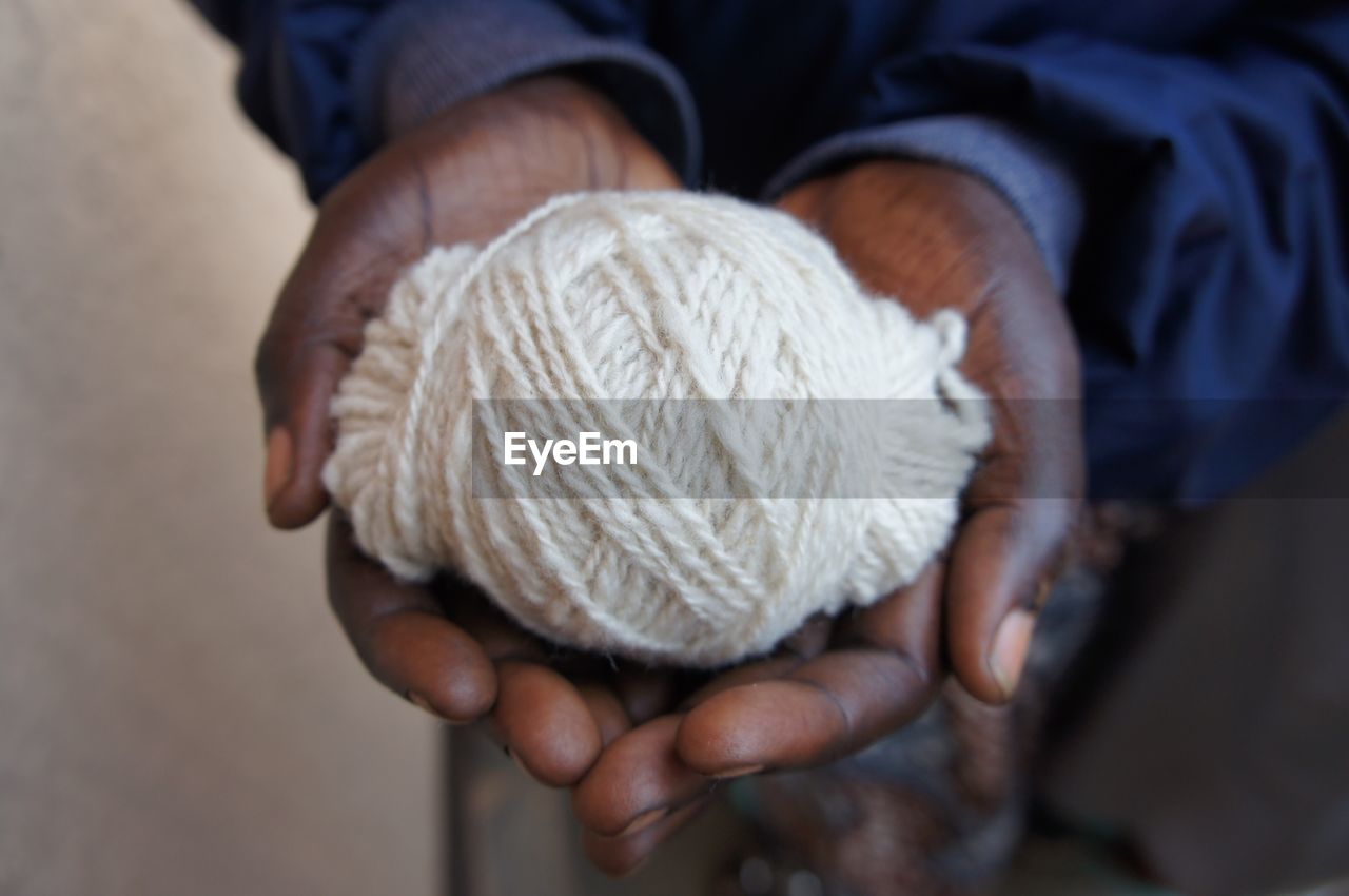 Midsection of man holding wool