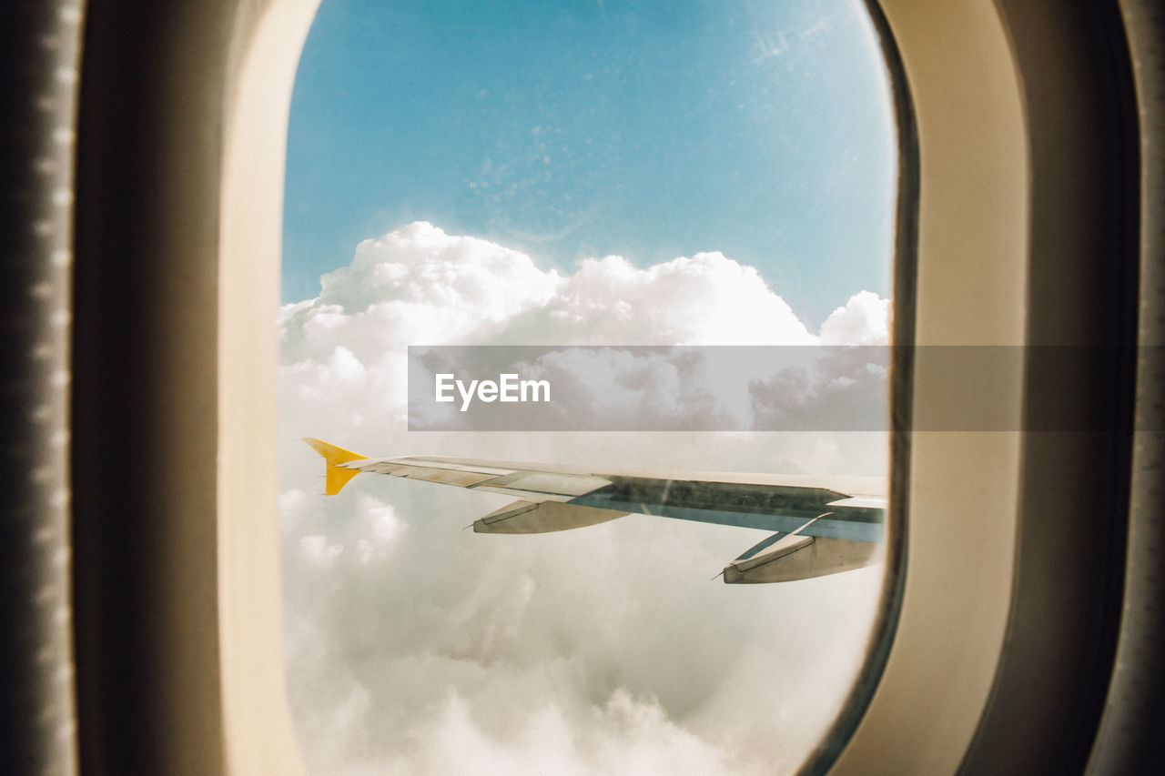 Airplane flying in sky seen through window