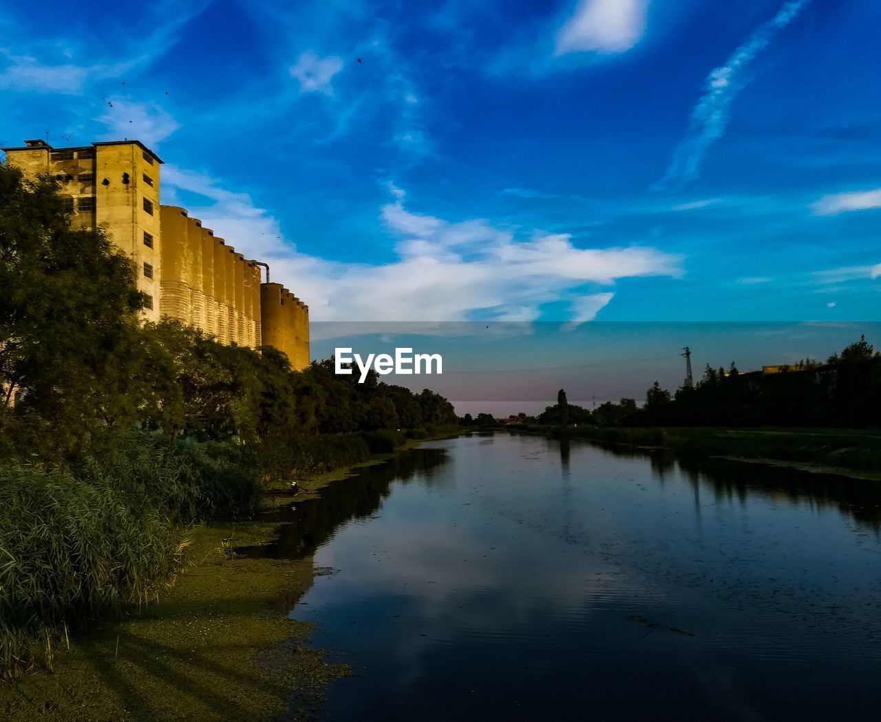 SCENIC VIEW OF LAKE BY BUILDINGS AGAINST SKY