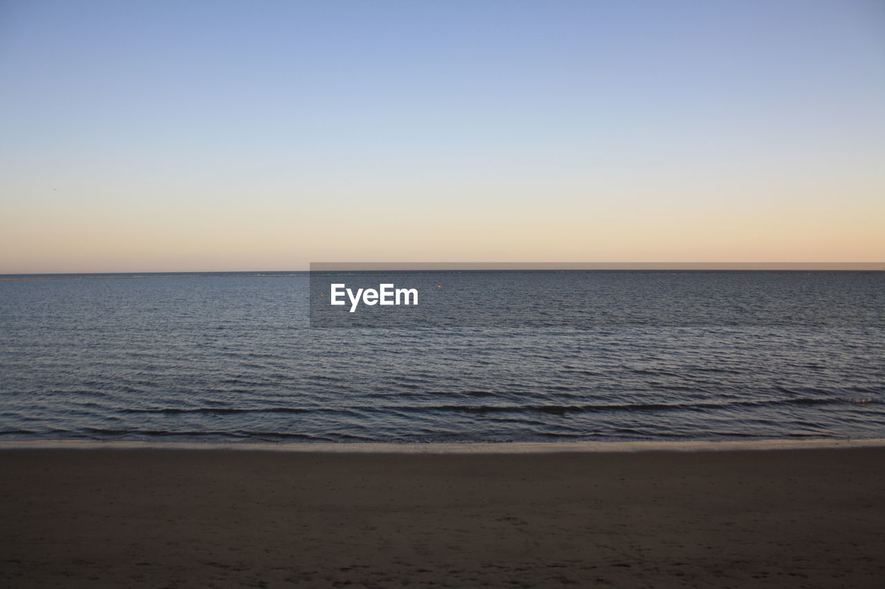 Scenic view of sea against clear sky during sunset