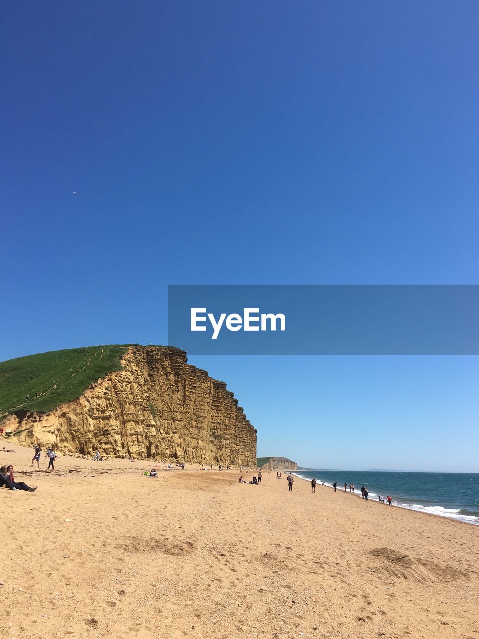 Scenic view of beach against clear blue sky