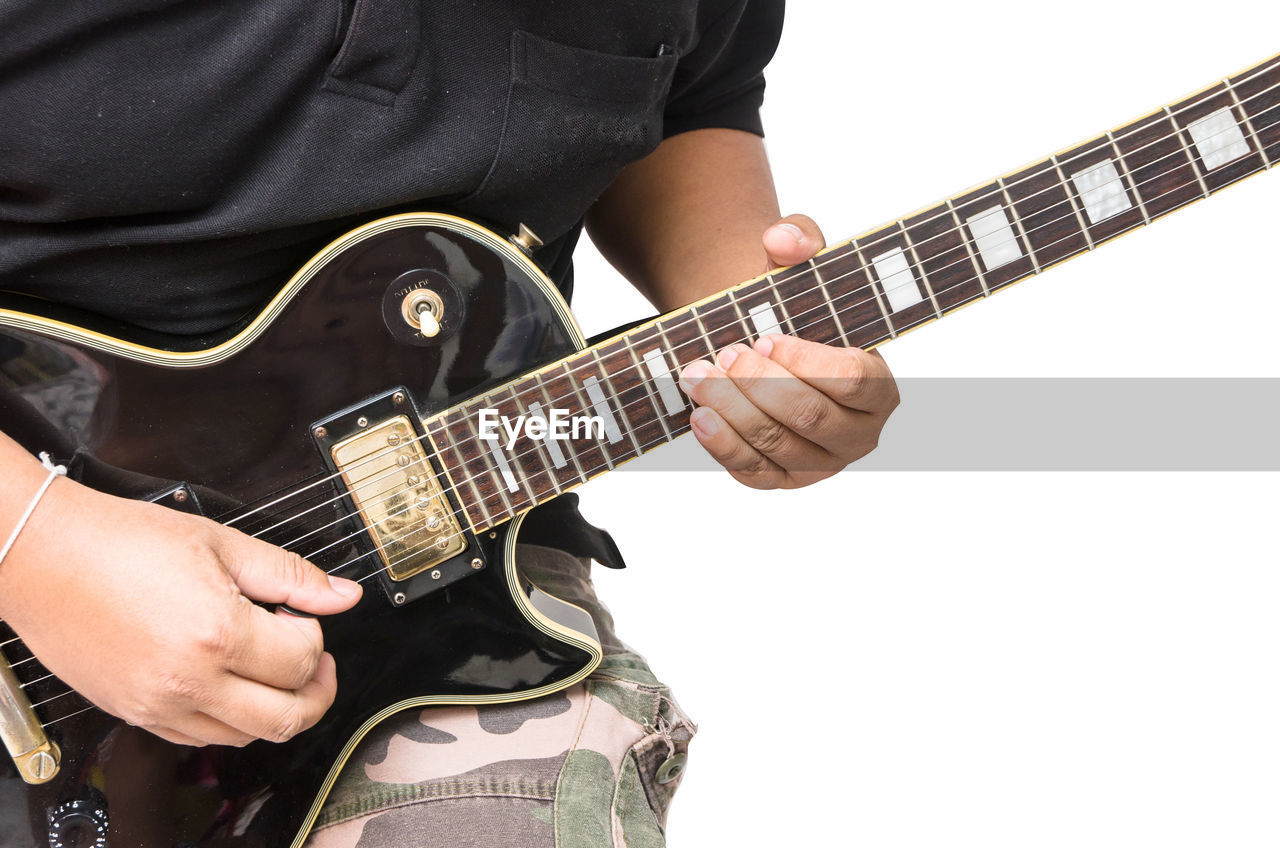 Midsection of man playing guitar against white background