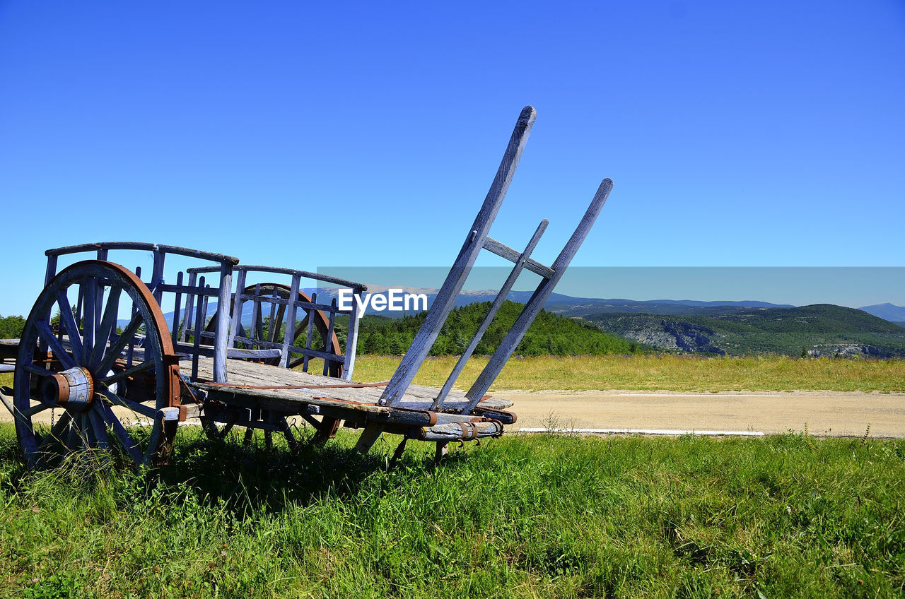 Low angle view of abandoned cart against blue sky