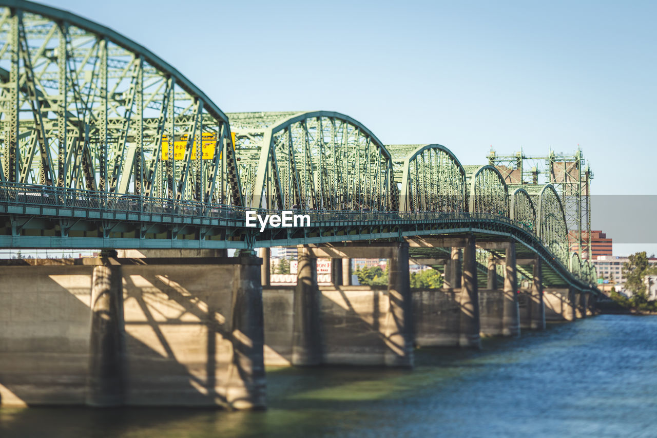 BRIDGE OVER RIVER AGAINST SKY IN CITY