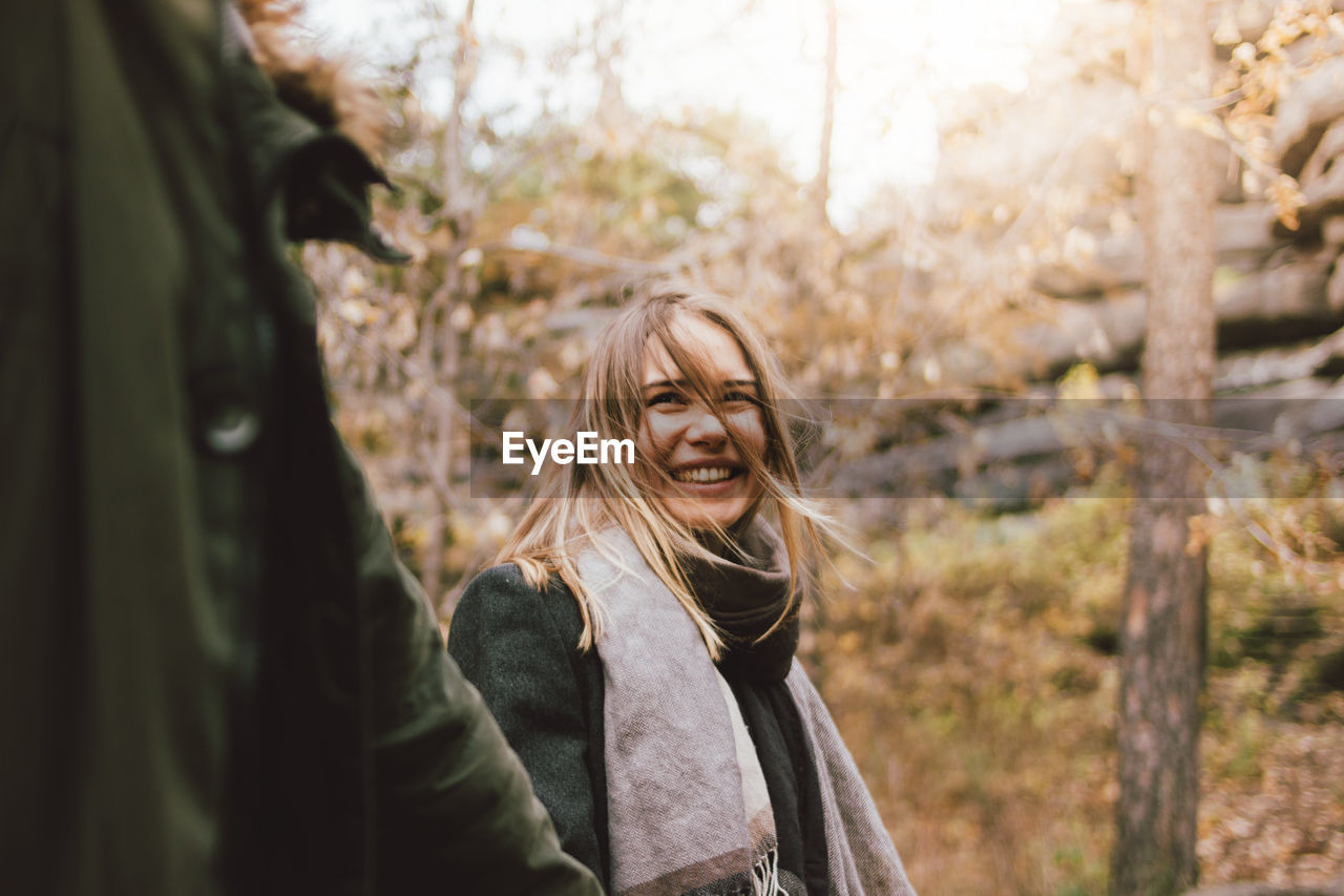 Smiling young woman looking away in forest