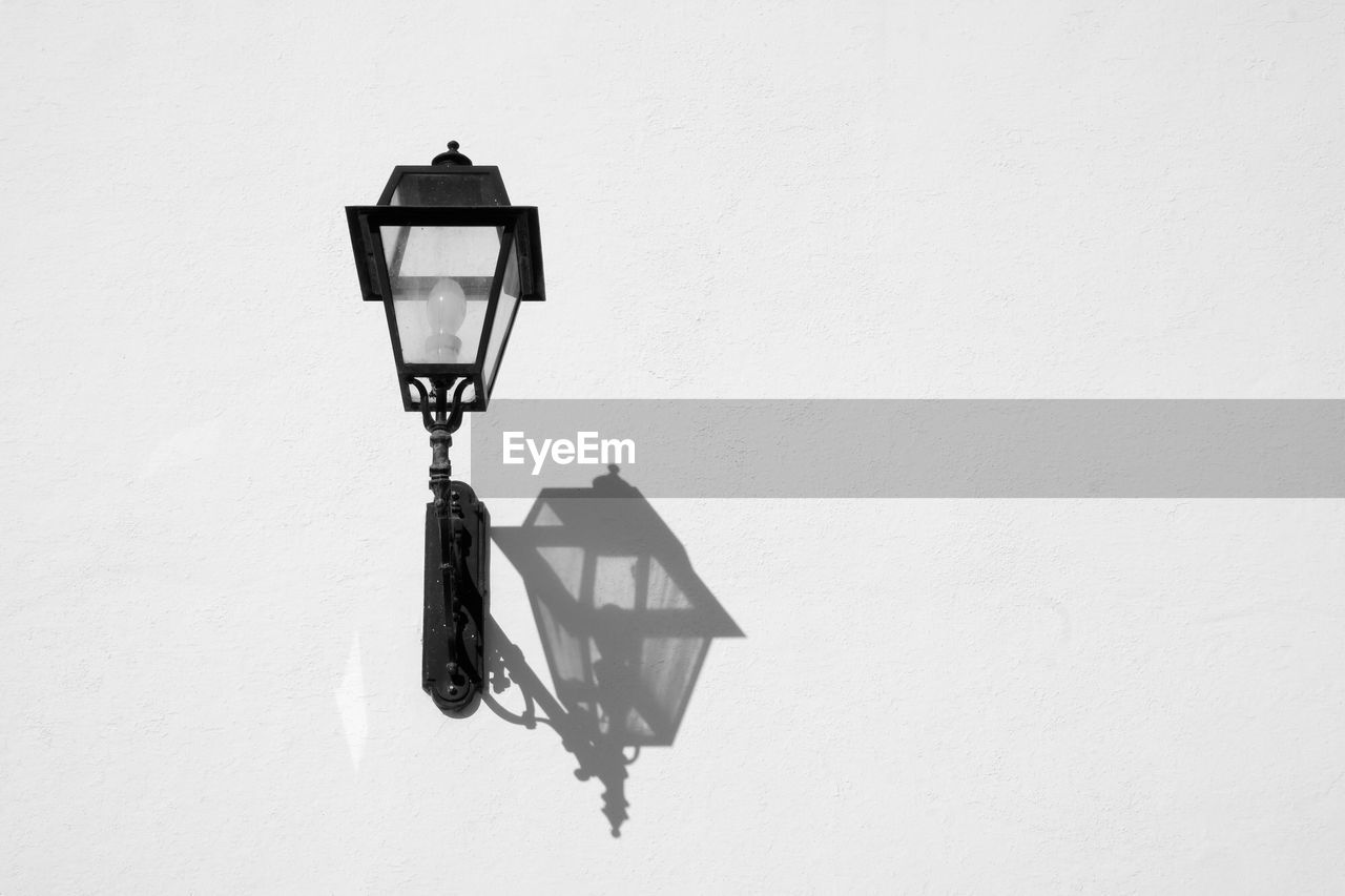 LOW ANGLE VIEW OF LAMP POST ON WALL