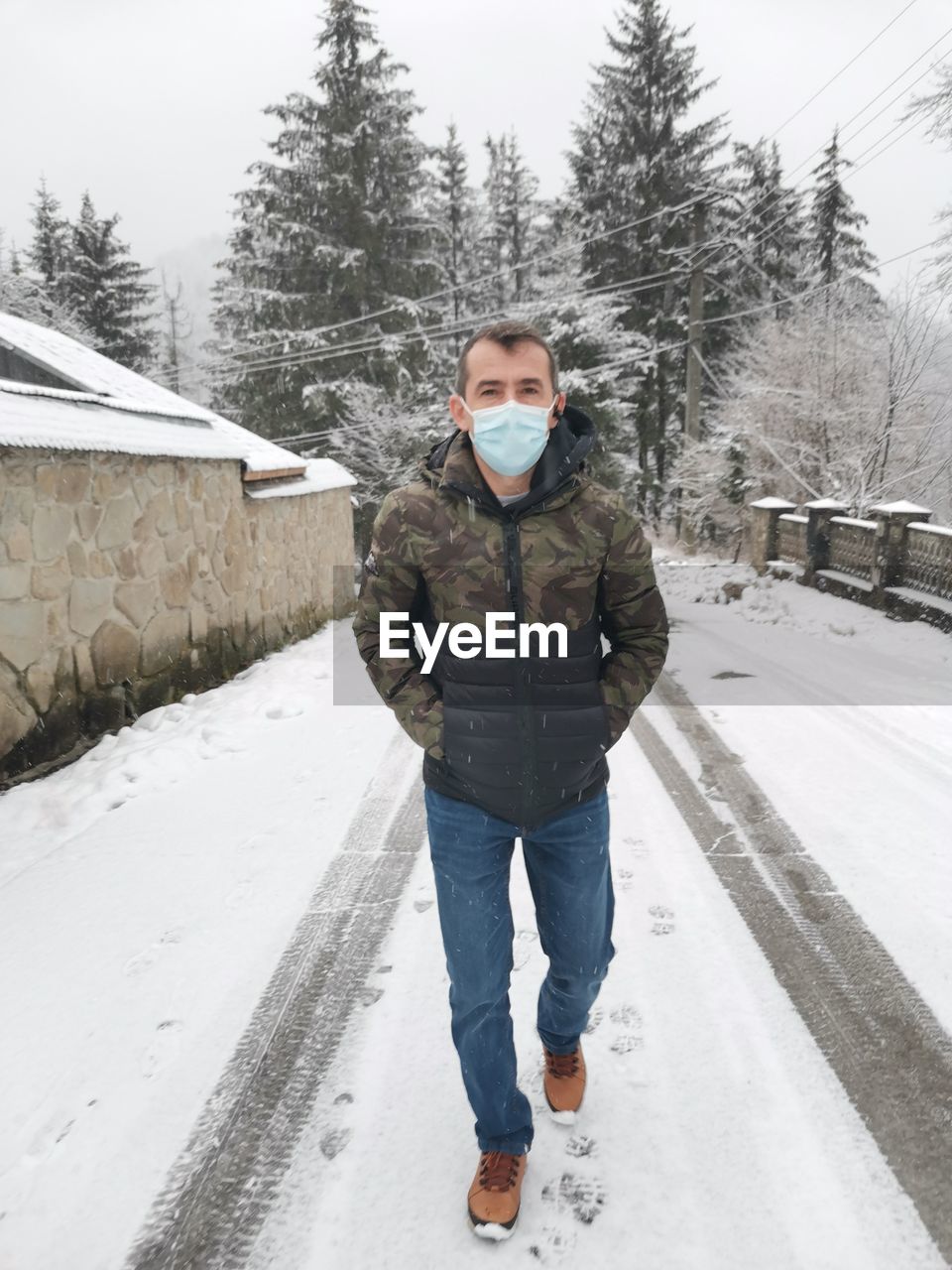 Full length portrait of man standing on snow covered field