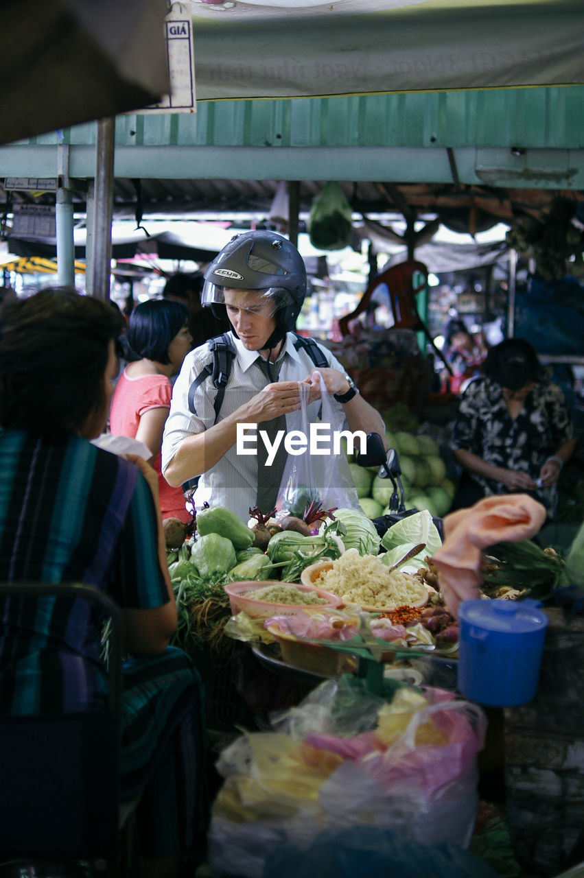 PEOPLE IN MARKET STALL