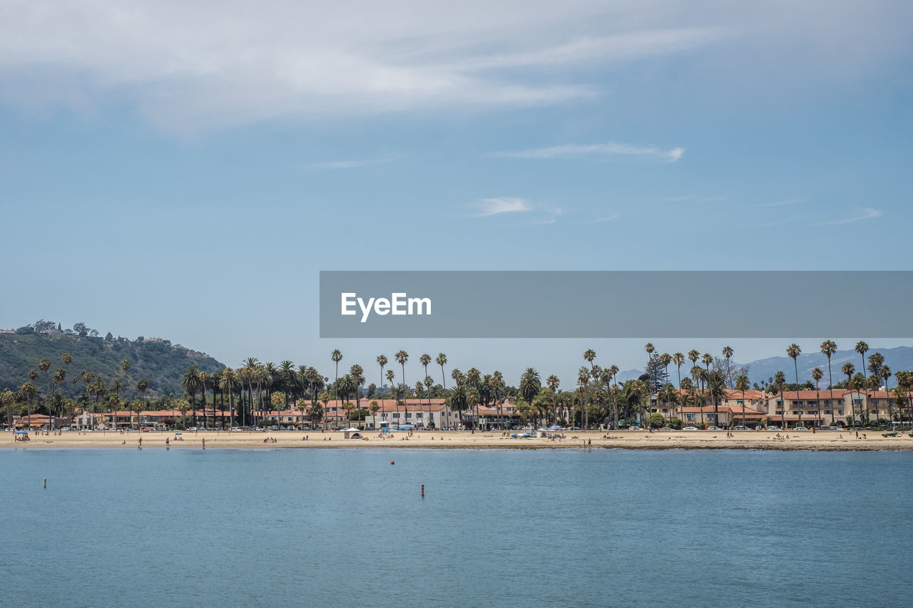 Scenic view of sea by town against sky