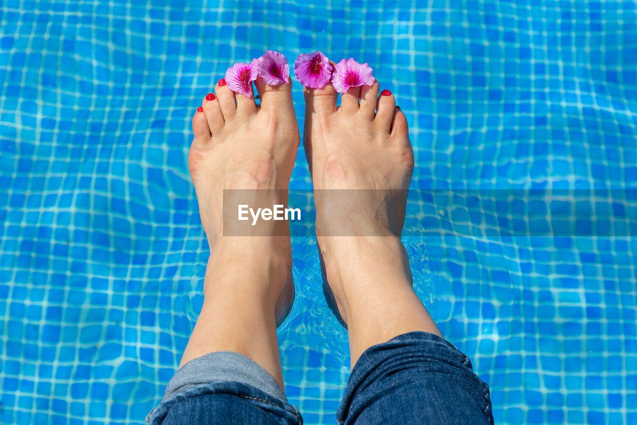 Low section of woman feet in swimming pool