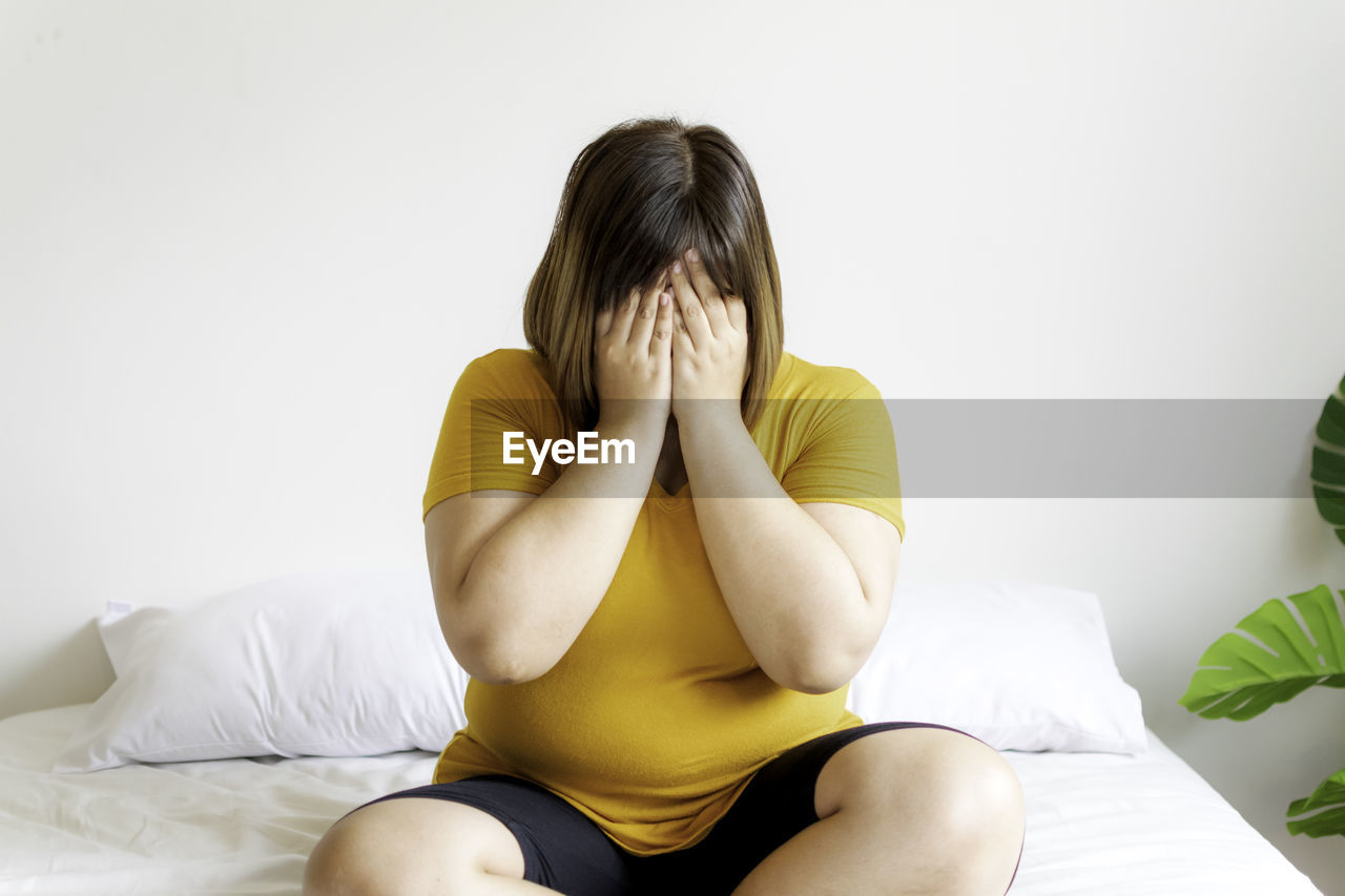 MIDSECTION OF WOMAN SITTING WITH HAIR