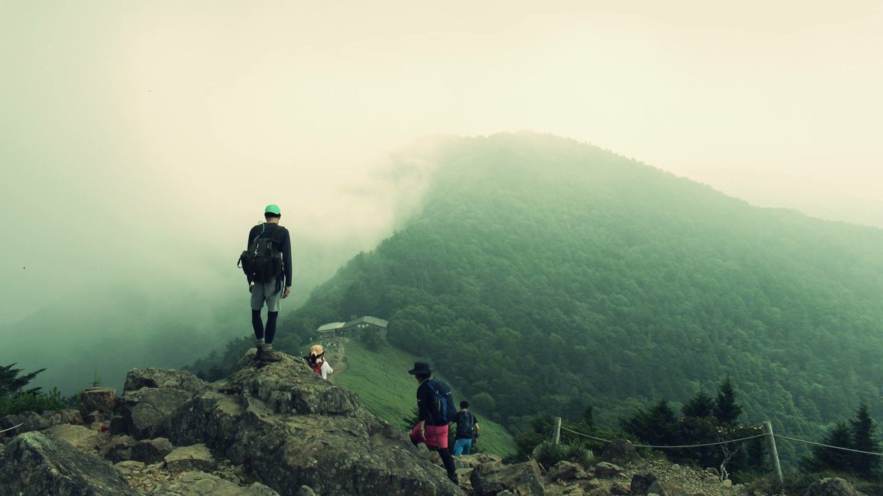 Rear view of people walking on country landscape