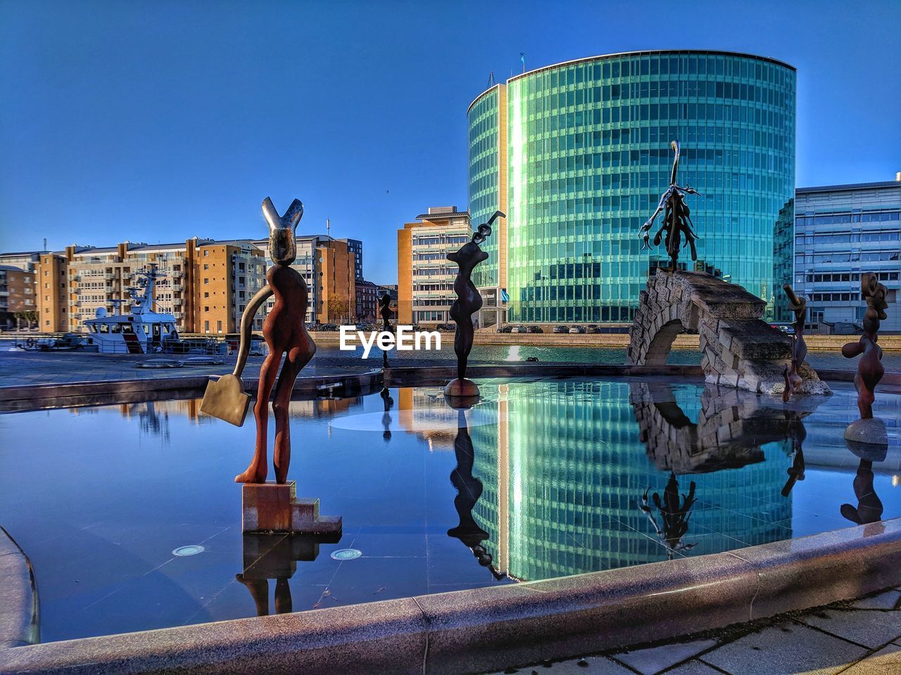 STATUE BY SWIMMING POOL AGAINST SKY