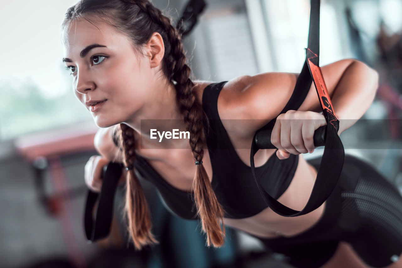 Close-up of beautiful woman exercising in gym