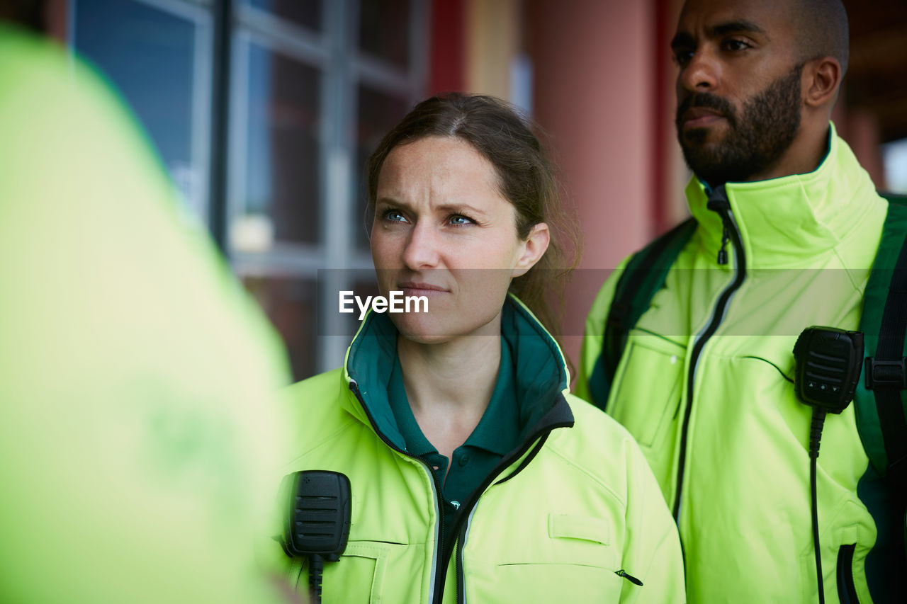 Female paramedic standing with coworker outside hospital