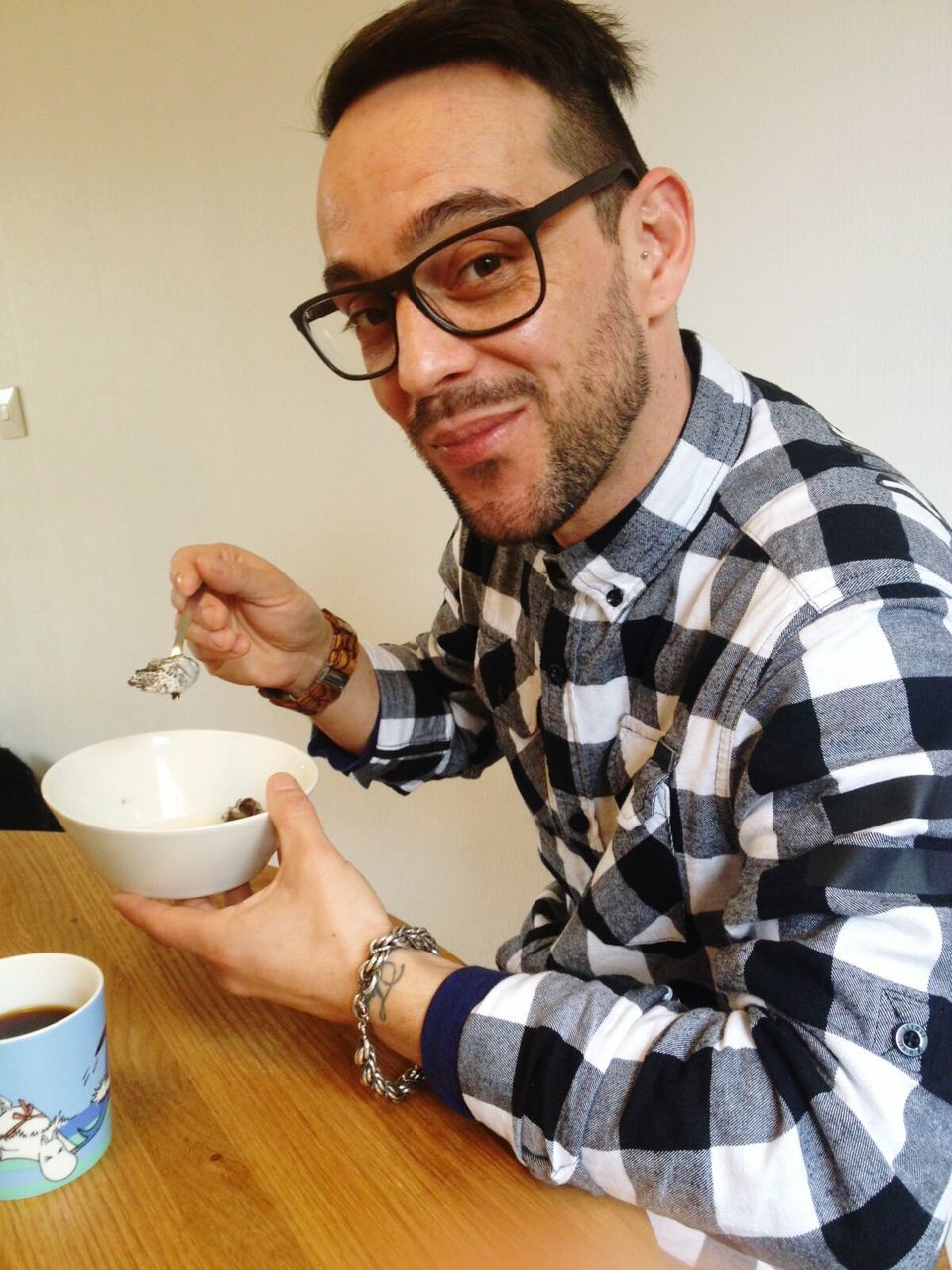 Portrait of smiling young man having food at table