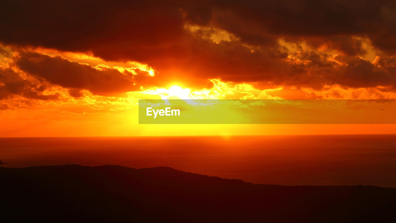 SCENIC VIEW OF SUNSET OVER SILHOUETTE MOUNTAIN