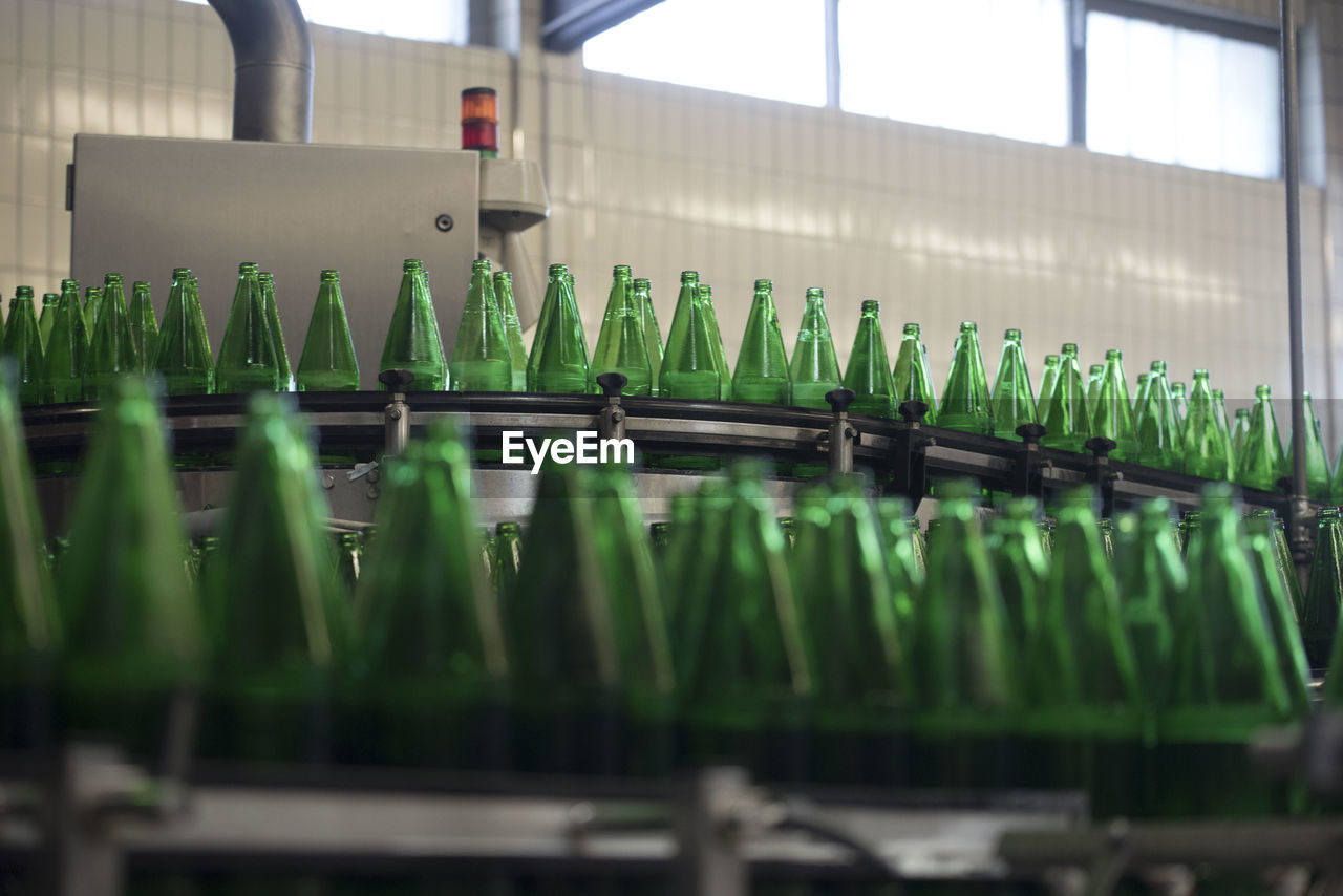 Bottling of water in green bottles, in an industrial plant