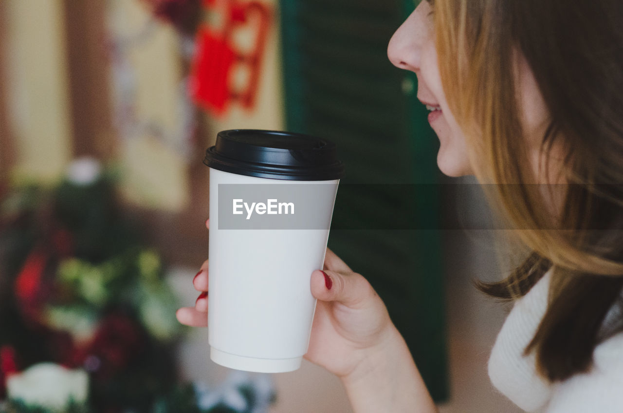 Midsection of woman having coffee during christmas