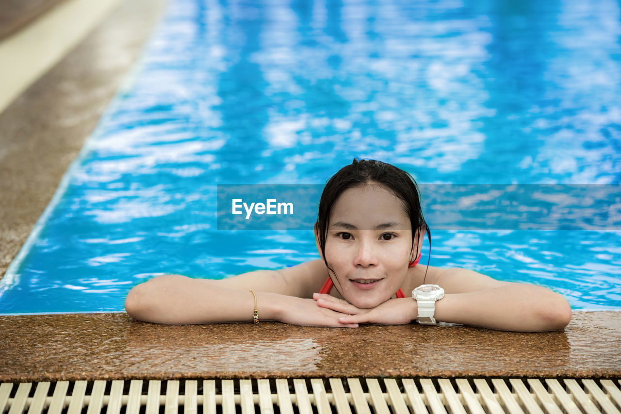 Portrait of young woman swimming in pool