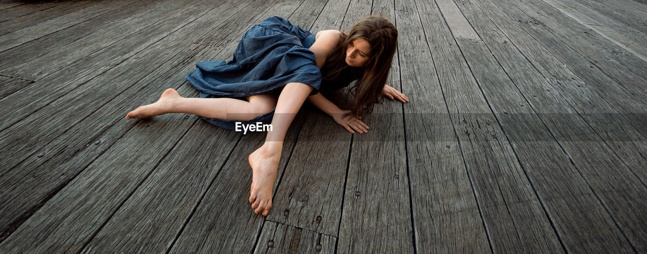 HIGH ANGLE VIEW OF WOMAN LYING DOWN ON FLOOR