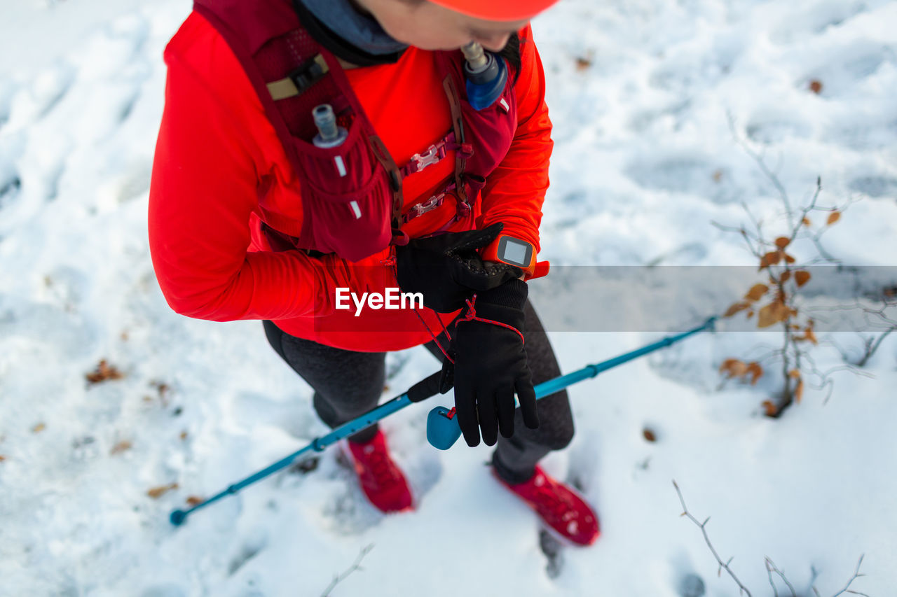 Top view of female runner setting up fitness smart watch for trail running.