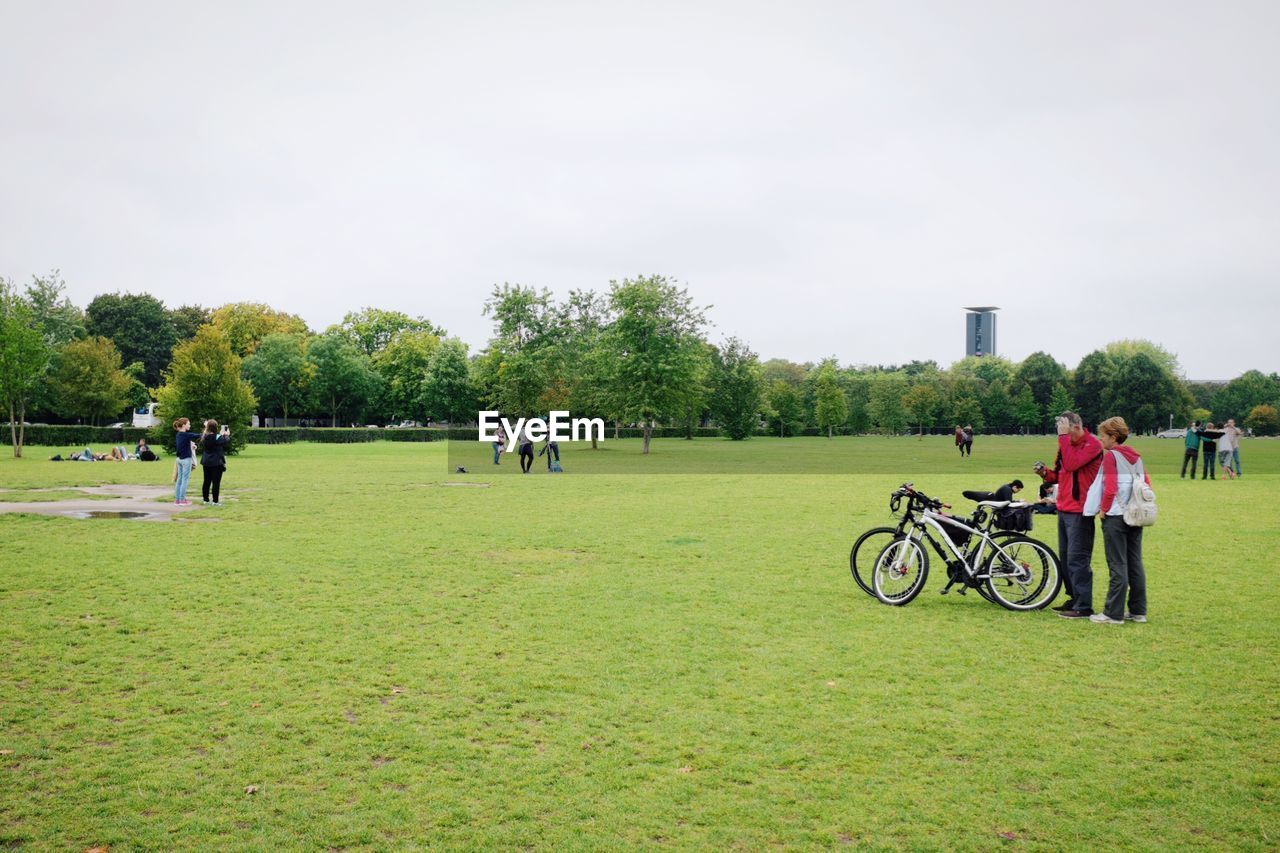 PEOPLE WALKING ON GRASSY FIELD IN PARK