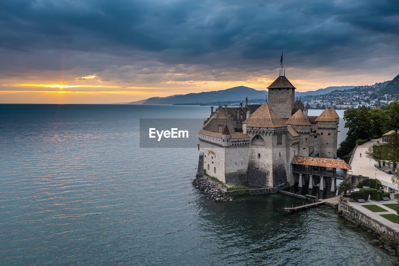 Switzerland, canton of vaud, veytaux, aerial view of lake geneva and chillon castle at cloudy sunset