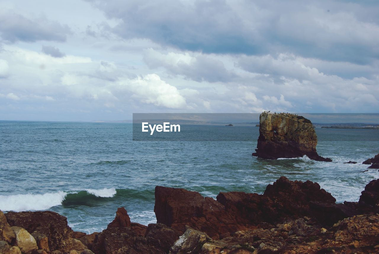 SCENIC VIEW OF ROCK FORMATION IN SEA AGAINST SKY