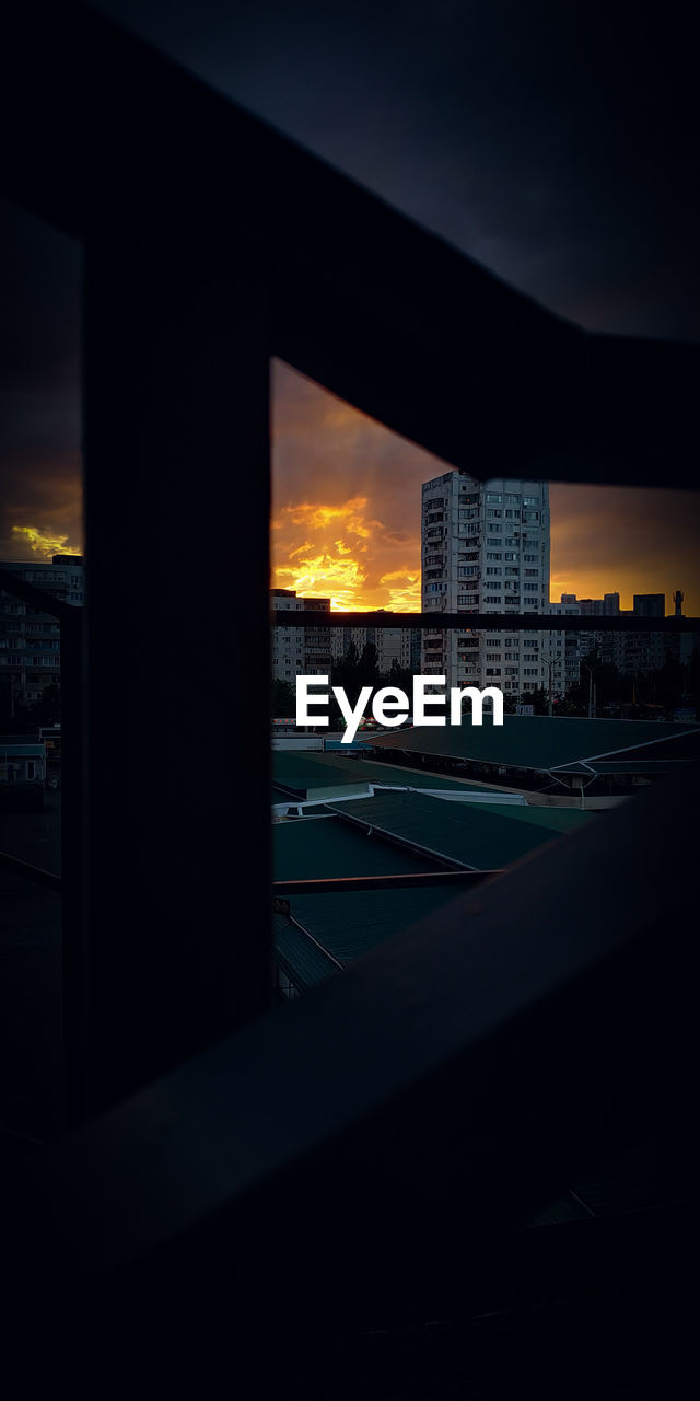 BUILDINGS SEEN THROUGH BRIDGE DURING SUNSET