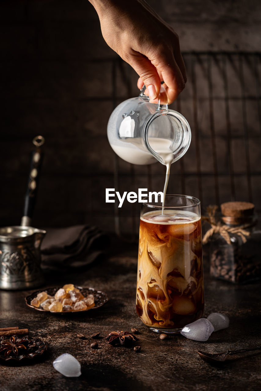 cropped hand of person pouring coffee