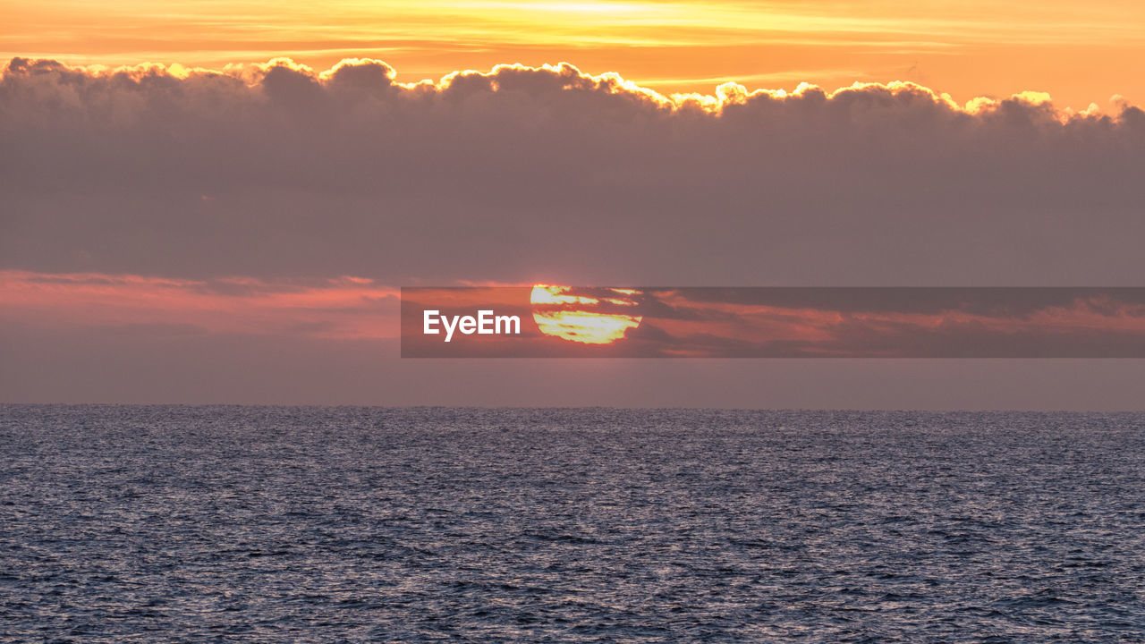 Scenic view of sea against orange sky
