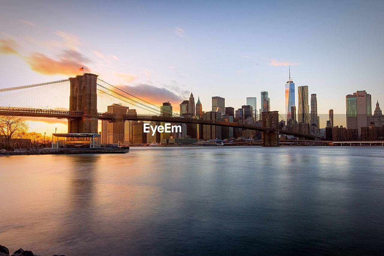 View of suspension bridge in city at sunset