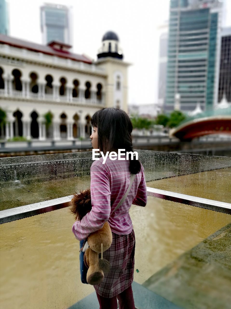 REAR VIEW OF WOMAN WITH UMBRELLA WALKING IN WATER