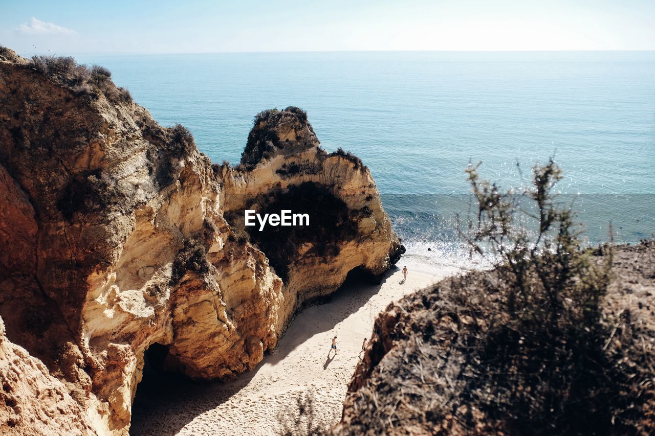 Rock formations by sea against sky