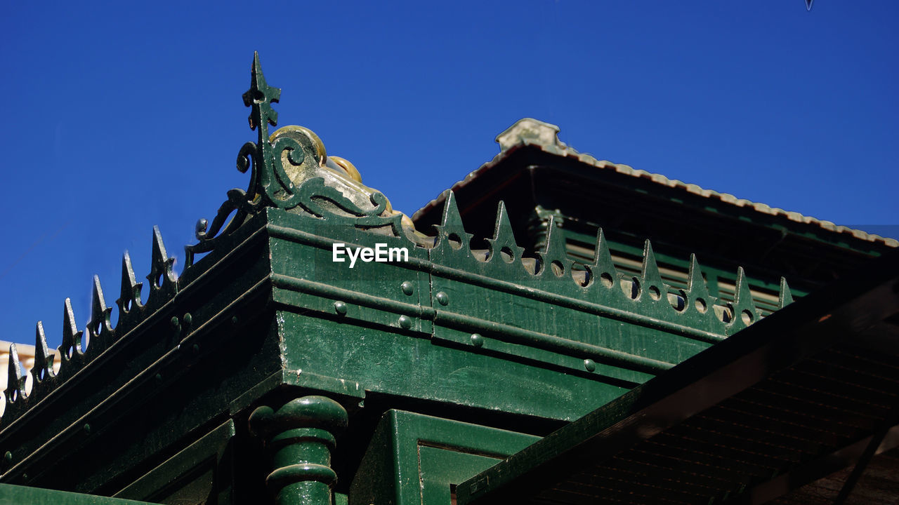 Low angle view of old building roof against sky