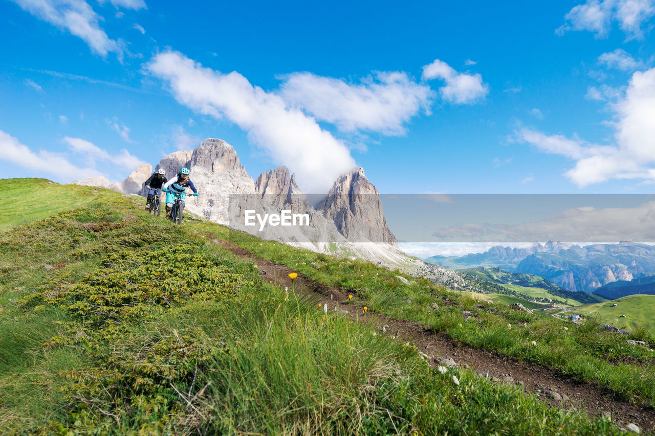 Low angle view of people riding bicycles on mountain