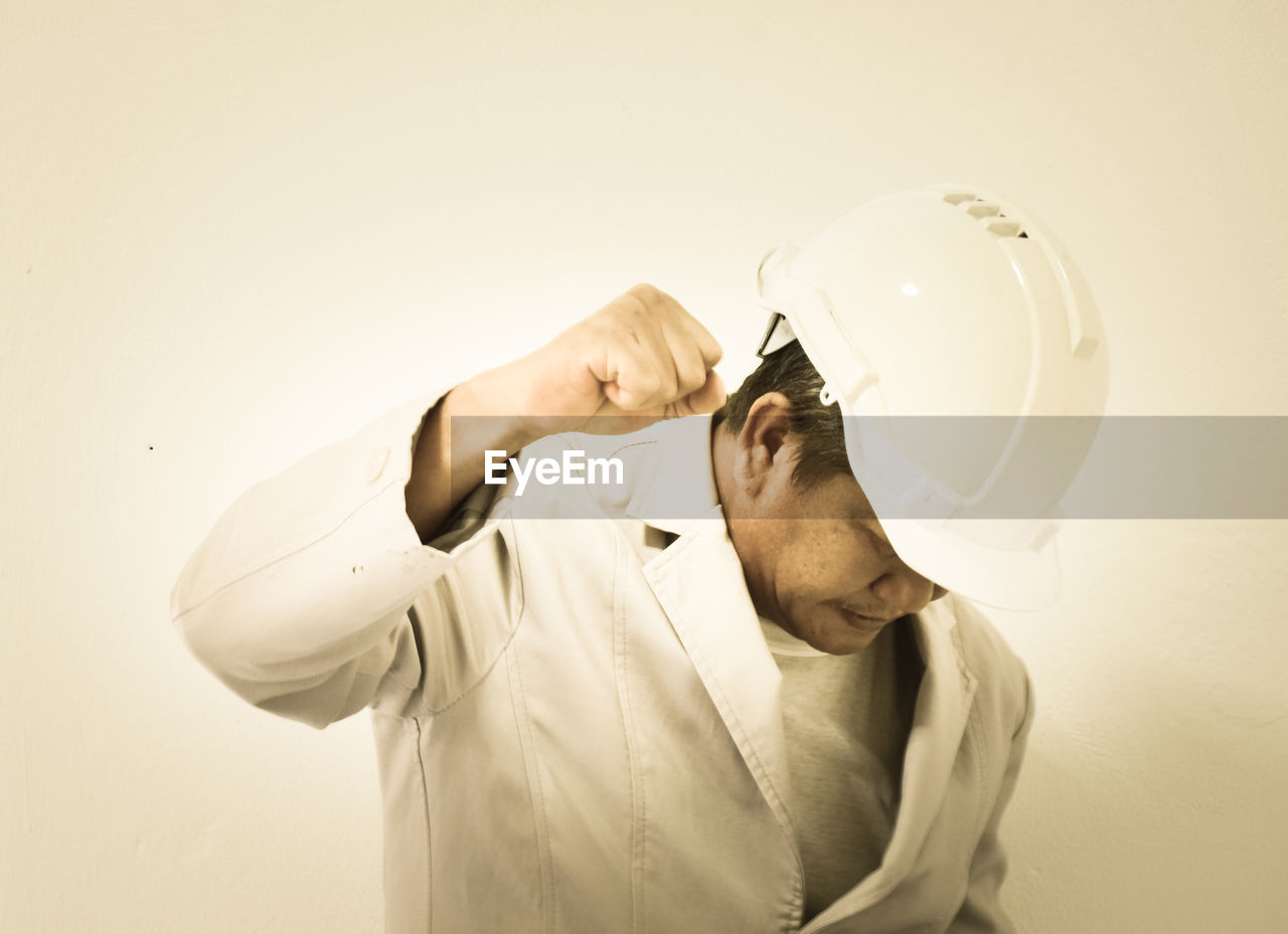 Engineer clenching fist against beige background