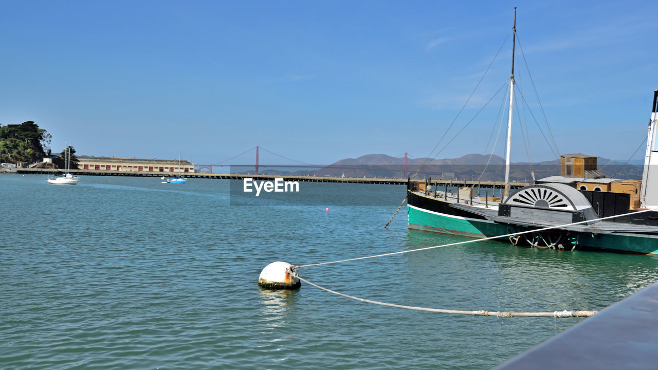 BOAT MOORED ON SEA AGAINST SKY