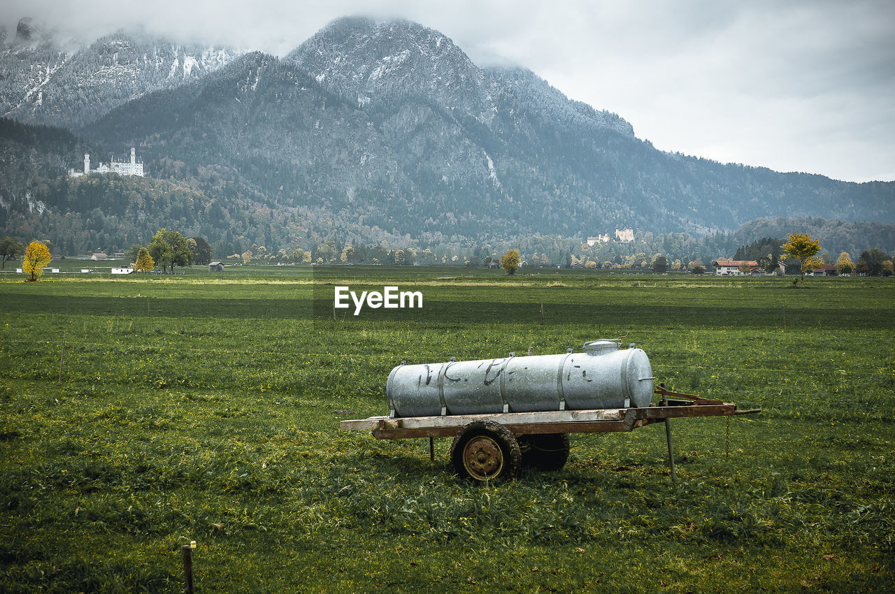 Tractor on field against mountain range