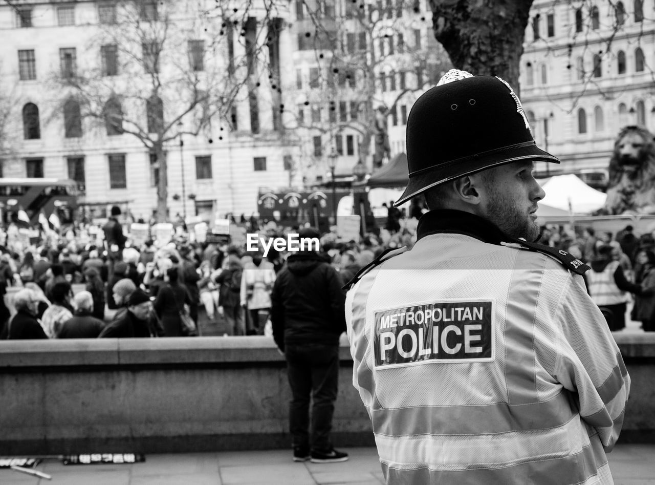 Rear view of police officer wearing reflective clothing in city