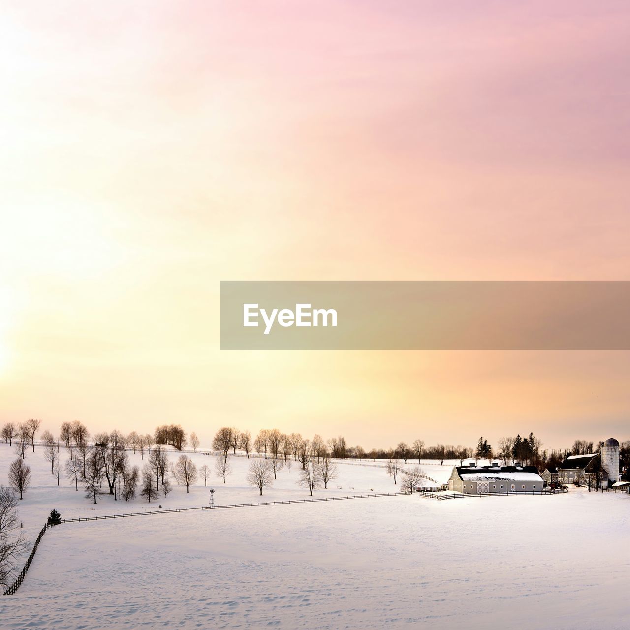 Scenic view of snowcapped landscape at sunset