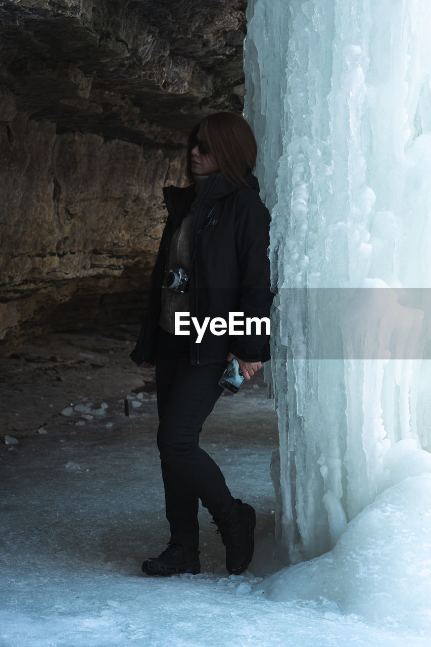  woman standing near ice wall 