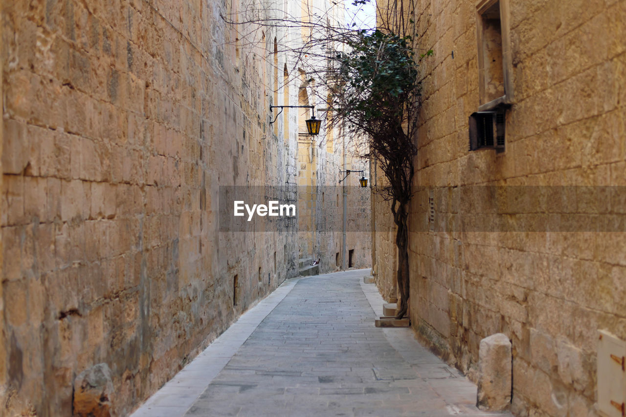 Beautiful narrow alley in malta with limestone walls