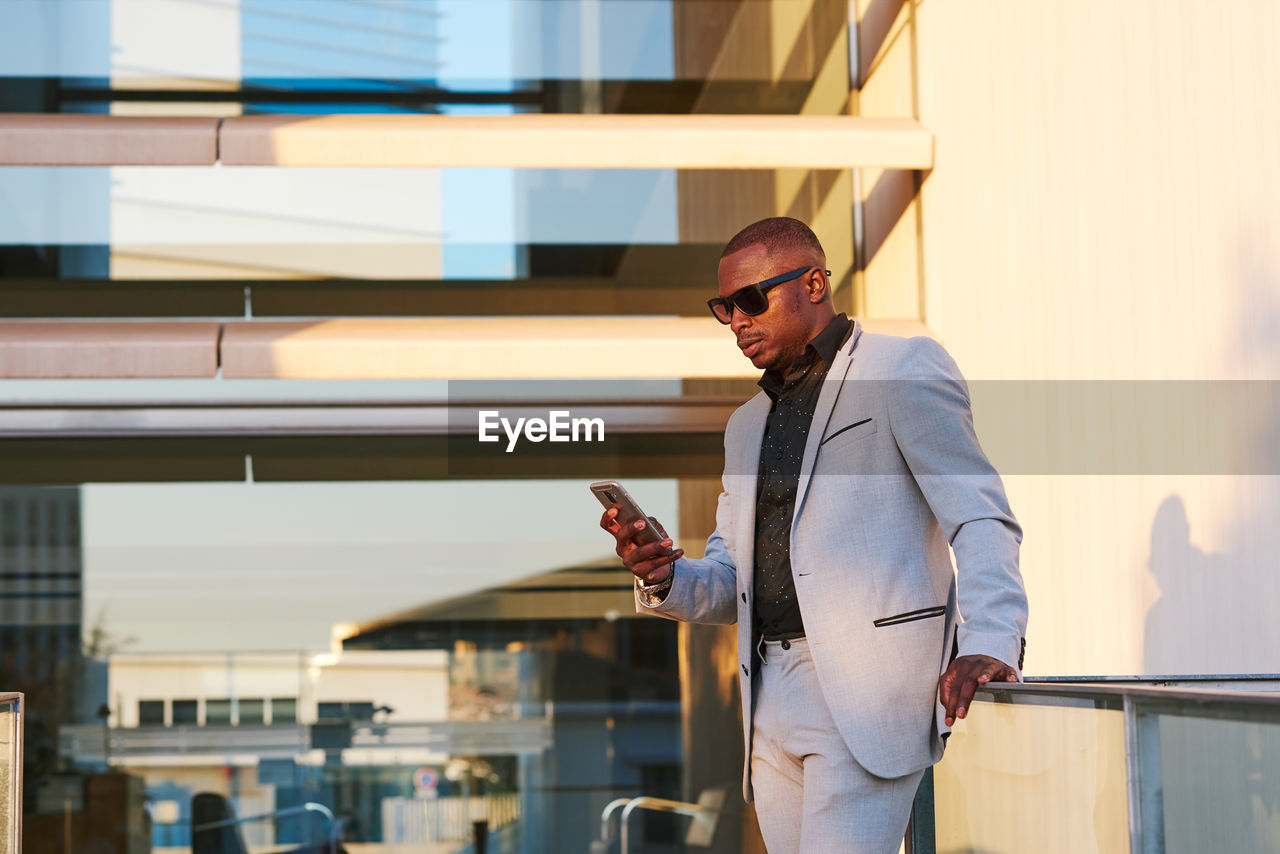 African american businessman with mobile phone on a summer afternoon.