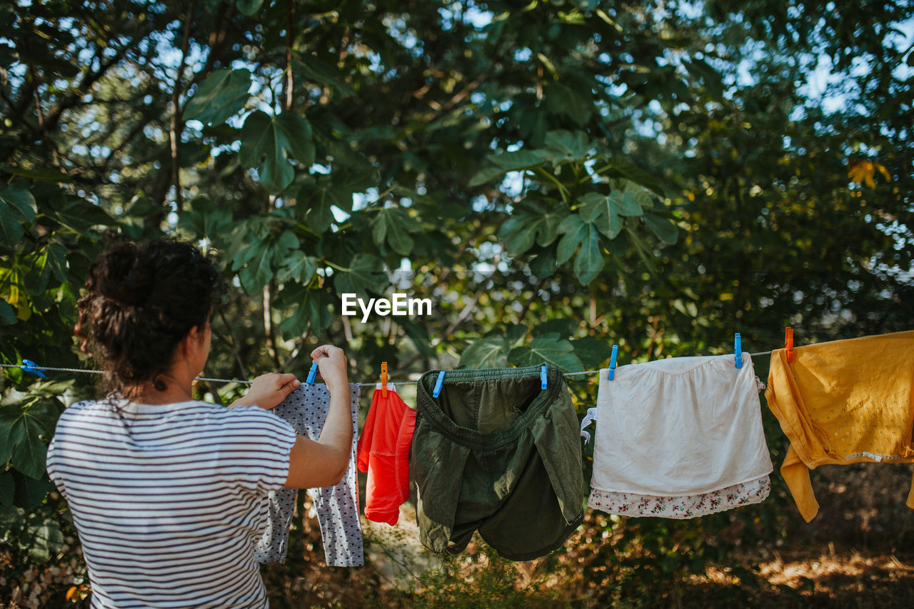 Rear view of woman drying clothes